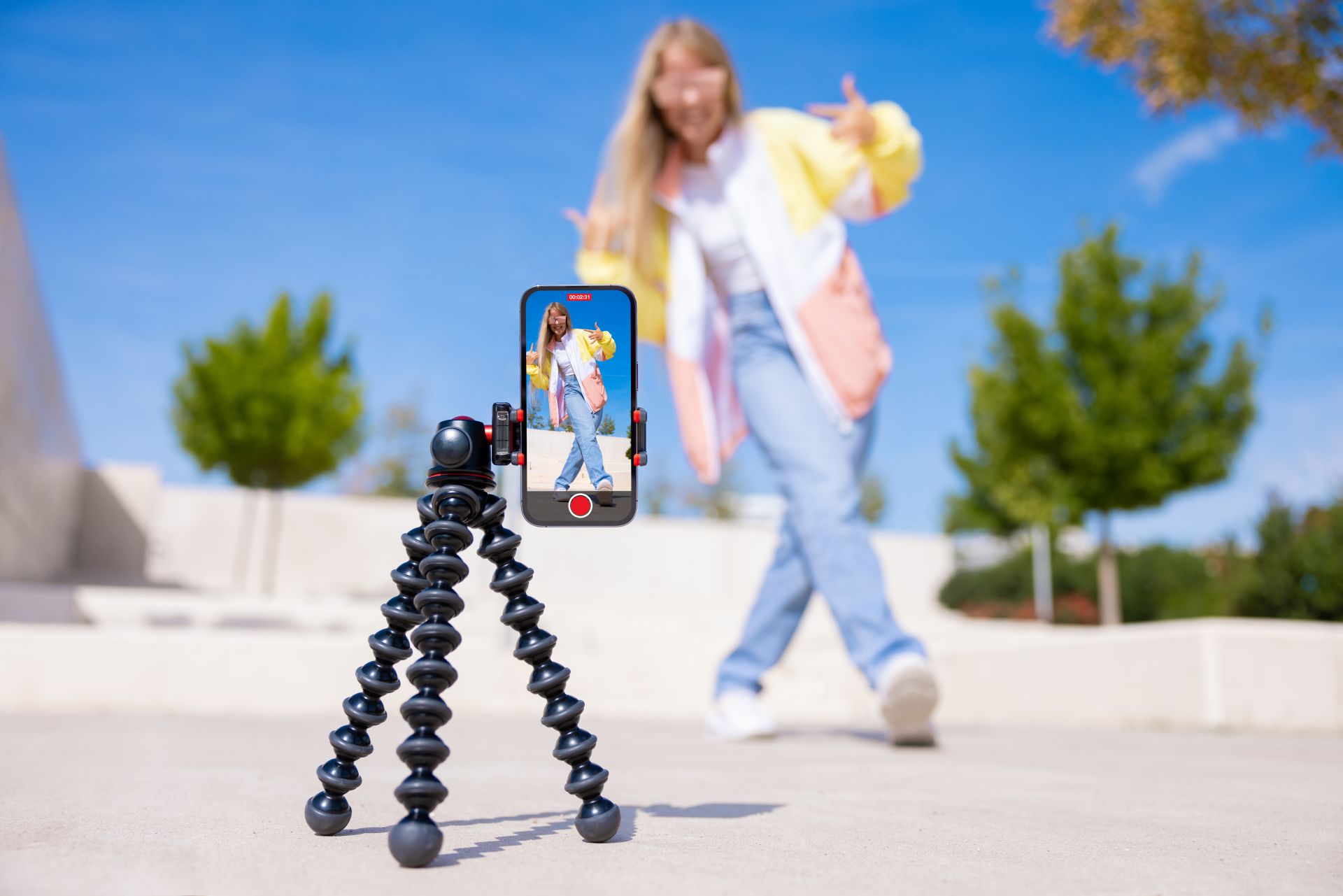 Teen girl posing for a phone camera on a tripod